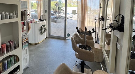 Modern Isla Hair salon interior in Maroochydore, Queensland, AU, with styling chairs and product display.