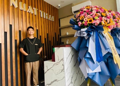 Reception at NUAT THAI Ortigas Extension in Cainta, Calabarzon, PH with staff and floral arrangement.