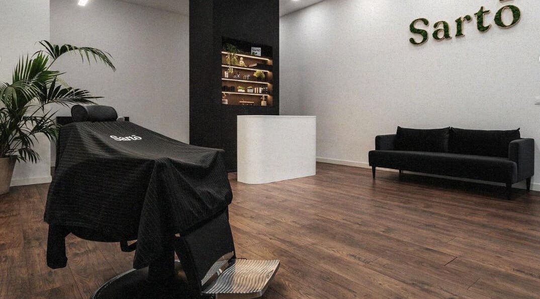 Sala acogedora y moderna en Sarto, Arteixo, ES, con sillón, planta y mostrador.