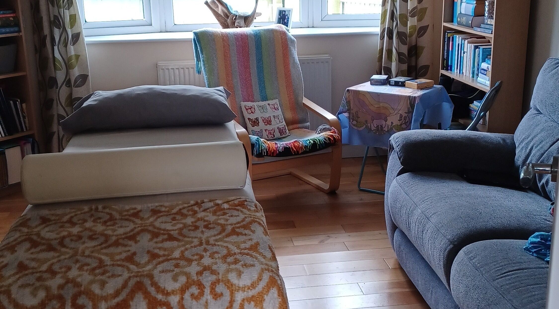 Cozy relaxation room at Kernow Serenity, Truro, England, GB, featuring a treatment bed and comfortable seating.