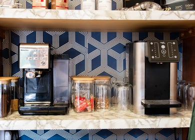 Chic coffee station at Glaysson Carvalho Hair Studio, London, England, GB, with modern machines and cozy decor.