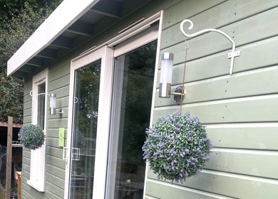 Exterior view of Grace & Glow in Maidstone, England featuring green siding with floral decor.