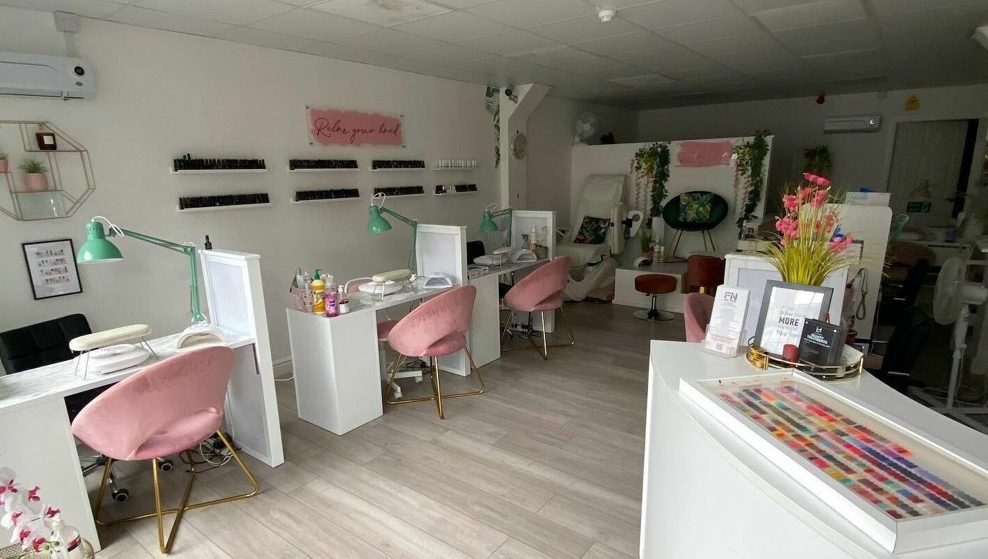 Inside FN Gel Bar, Rowley Regis, England, GB - stylish and modern nail salon with pink chairs and nail polish wall.