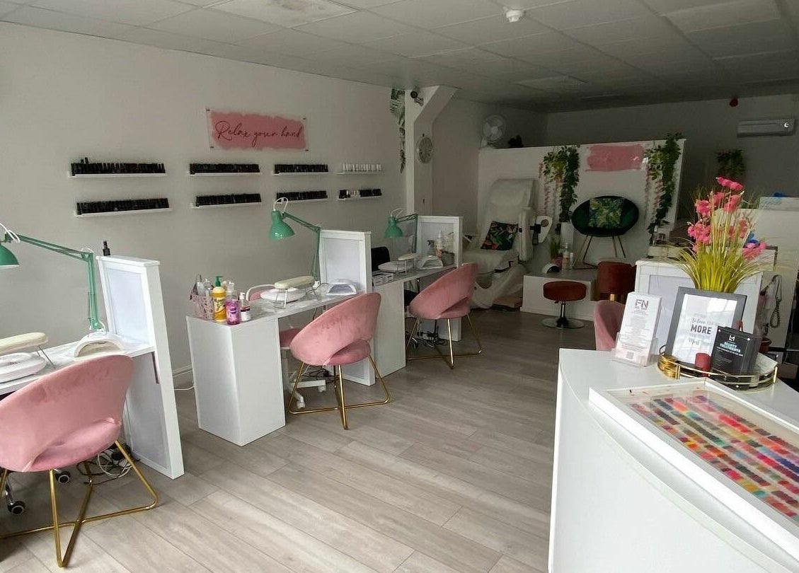 Inside FN Gel Bar, Rowley Regis, England, GB - stylish and modern nail salon with pink chairs and nail polish wall.