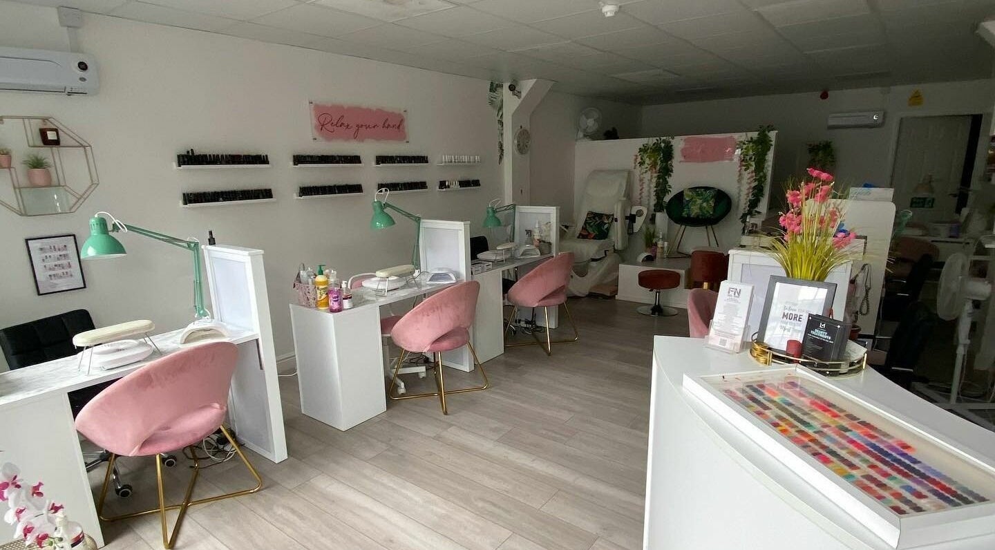 Inside FN Gel Bar, Rowley Regis, England, GB - stylish and modern nail salon with pink chairs and nail polish wall.