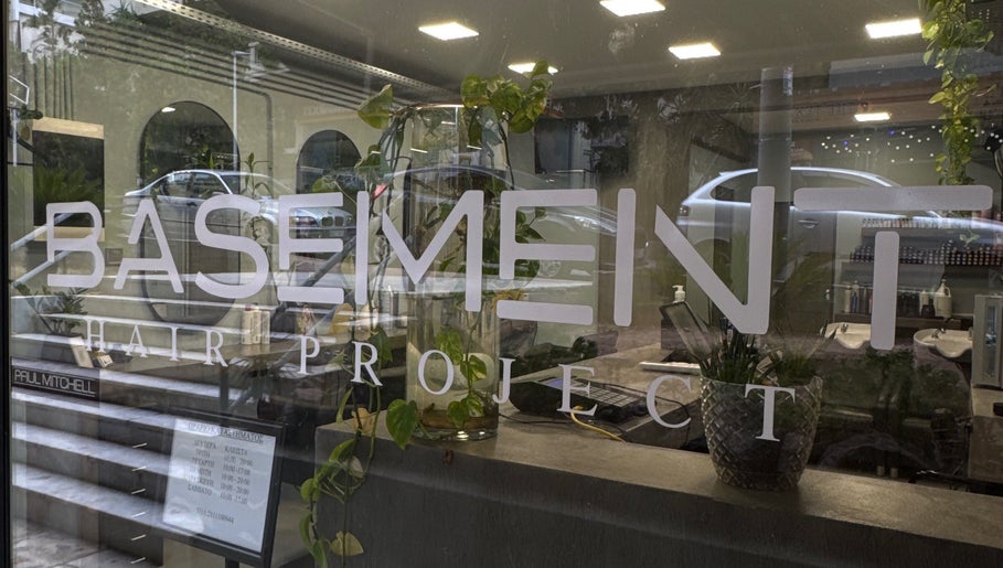 Η είσοδος του Basement Hair Project στην Αγία Παρασκευή, GR με μοντέρνα διακόσμηση και φυτά.