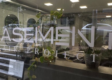Η είσοδος του Basement Hair Project στην Αγία Παρασκευή, GR με μοντέρνα διακόσμηση και φυτά.