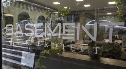 Η είσοδος του Basement Hair Project στην Αγία Παρασκευή, GR με μοντέρνα διακόσμηση και φυτά.