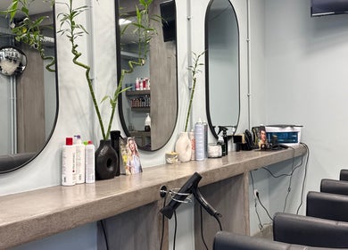 Καλαίσθητη εσωτερική διακόσμηση στο Basement Hair Project, Αγία Παρασκευή, GR με καθρέφτες και προϊόντα μαλλιών.