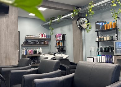 Καλαίσθητος χώρος κομμωτηρίου στο Basement Hair Project, Αγία Παρασκευή, GR με κομψά καθίσματα και προιόντα ομορφιάς.
