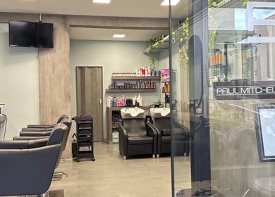 Εσωτερικό του Basement Hair Project, Αγία Παρασκευή, GR, με καθίσματα και εξοπλισμό κομμωτηρίου.
