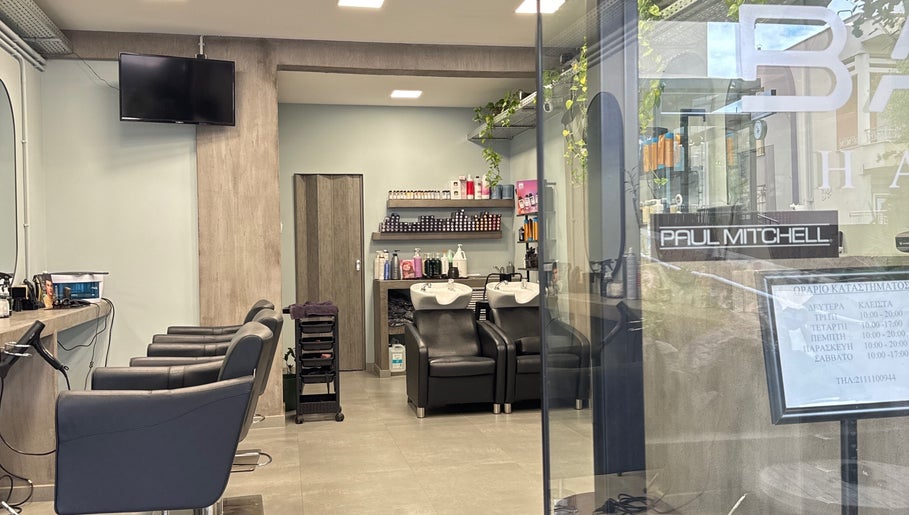 Εσωτερικό Basement Hair Project στην Αγία Παρασκευή, GR με κομψές καρέκλες και προϊόντα περιποίησης.