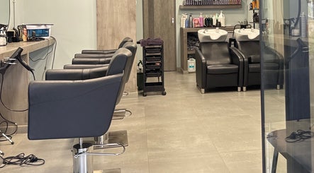 Σύγχρονος χώρος του Basement Hair Project στην Αγία Παρασκευή, GR με κομμωτηριακές καρέκλες και νιπτήρες.