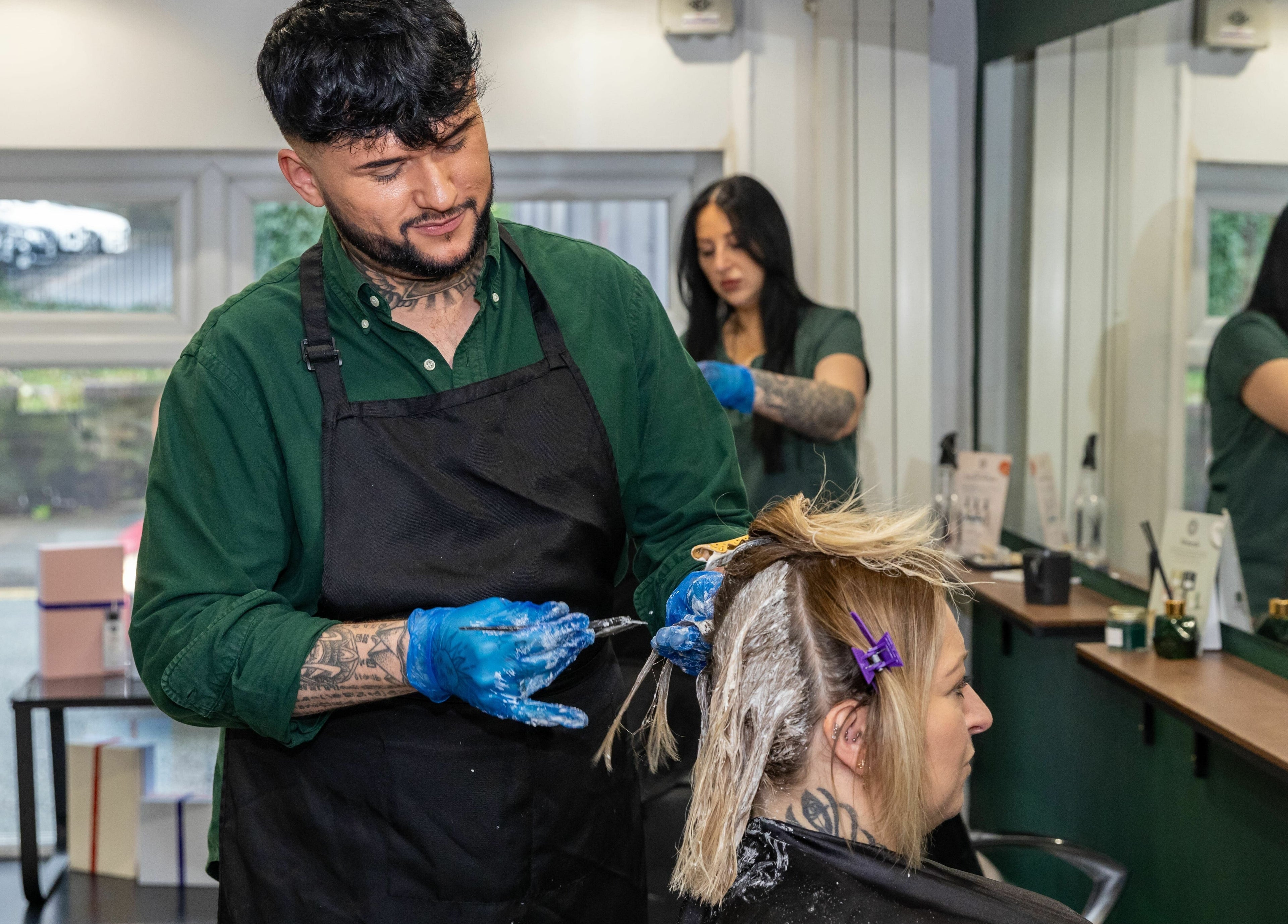 Hair stylist at The House of Castelliś in Hyde, England, GB enhancing client's hair with expert techniques.