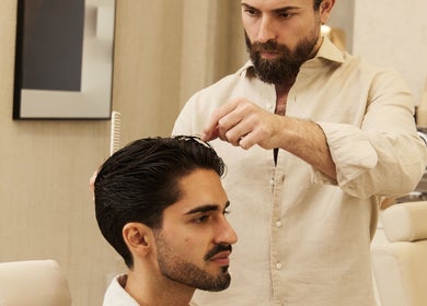 Barber styling a client's hair at Kochi Dubai Gents Salon, Dubai, Dubai, AE, showcasing professional grooming.