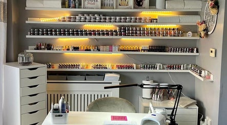 Cozy nail salon setup at Pampered Beauty, Elphinstone, Scotland, GB with shelves of nail products.