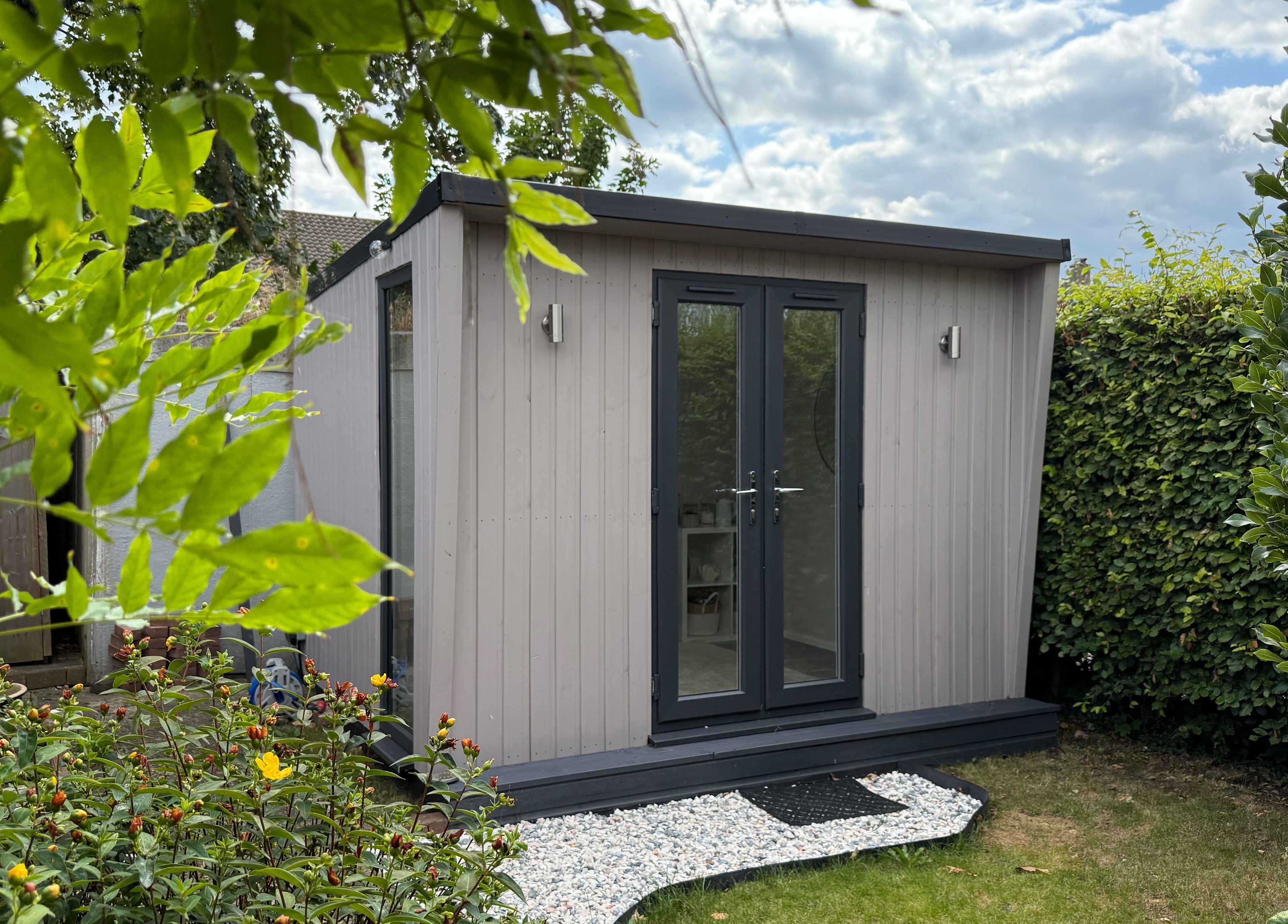 Cozy garden studio at Manis By Mais, Epsom, England, GB, surrounded by lush greenery.