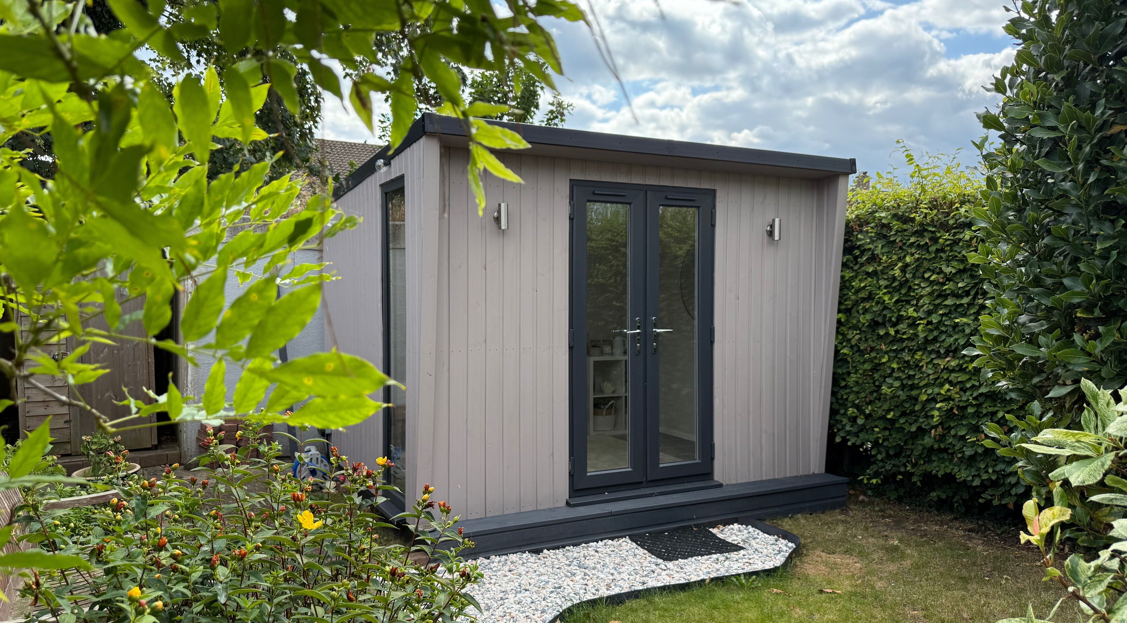 Cozy garden studio at Manis By Mais, Epsom, England, GB, surrounded by lush greenery.