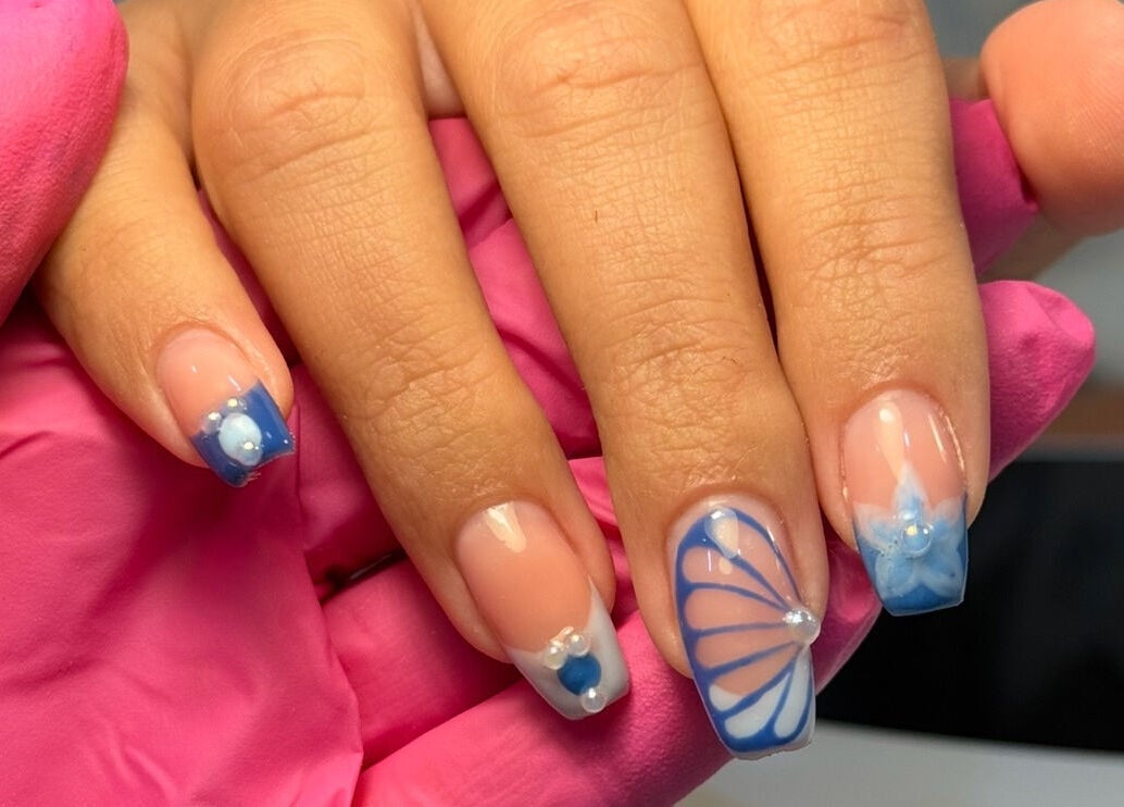 Elegant blue nail art at Manis By Mais, Epsom, England, GB, showcasing delicate designs and intricate patterns.