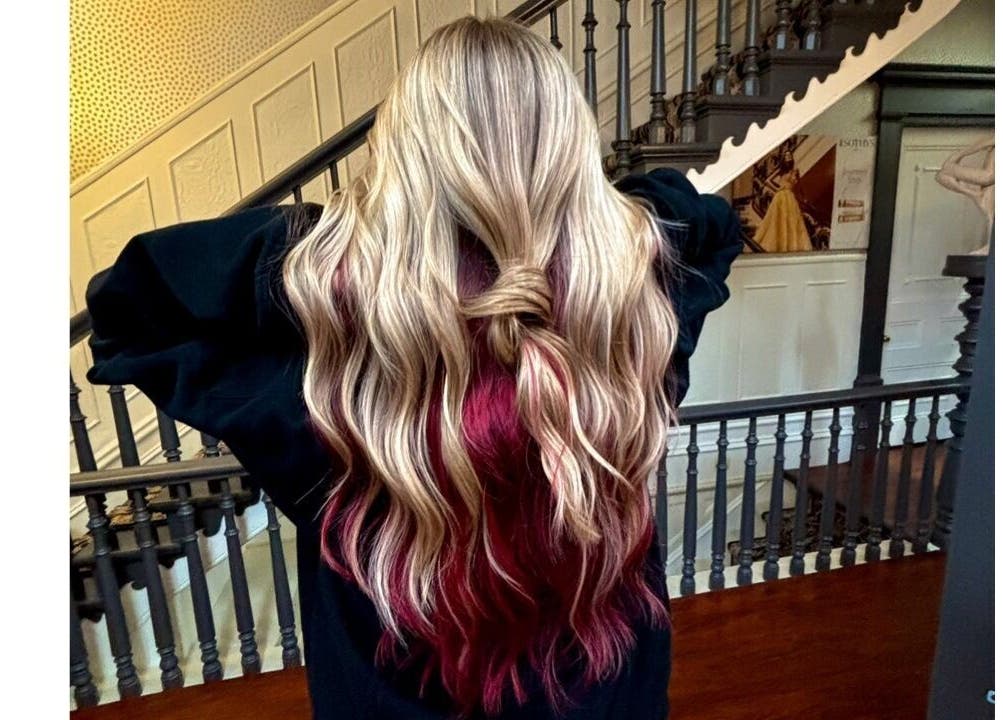 Cheveux blond et rouge ondulés chez Hairby.Élodie, Montmagny, Québec, CA. Style élégant sur un escalier.