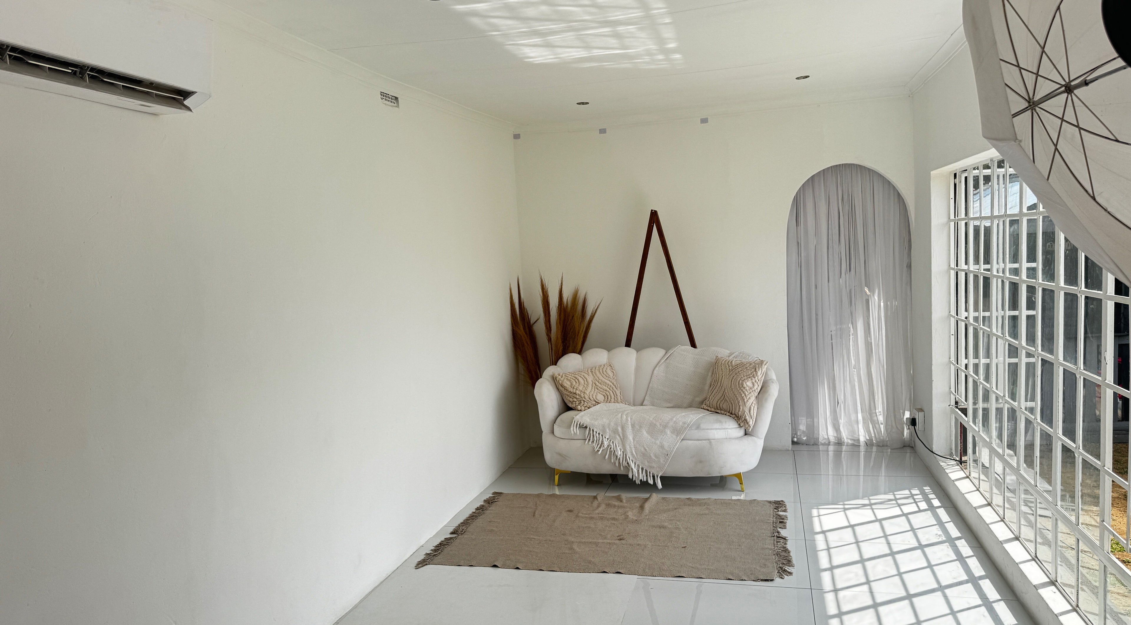 Bright studio at Morganite Photography in Alberton, Gauteng, ZA, featuring a cozy white sofa and natural light.