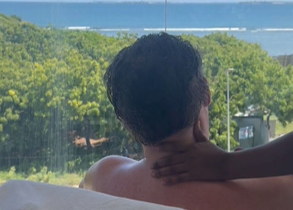 Therapist at ESPER SPA, Dar Es Salaam, TZ, giving a massage with a serene ocean view in the background.