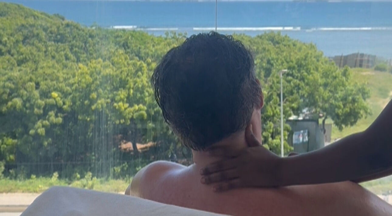 Therapist at ESPER SPA, Dar Es Salaam, TZ, giving a massage with a serene ocean view in the background.