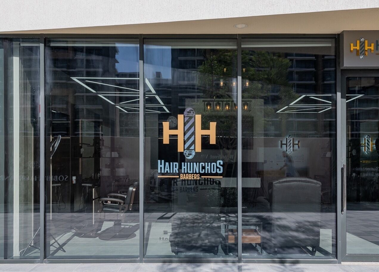 Front view of Hair Hunchos Barbers in Dubai, Dubai, AE, showcasing modern glass facade.