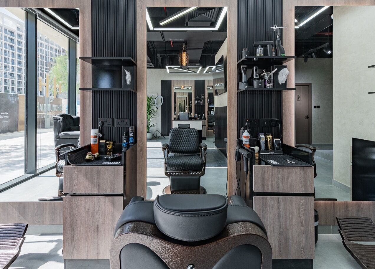 Modern interior of Hair Hunchos Barbers in Dubai, Dubai, AE, featuring stylish chairs and decor.