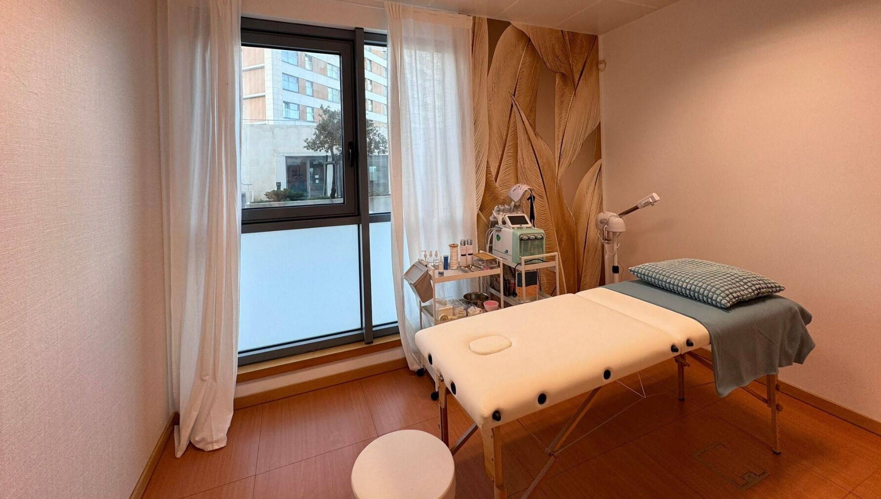 Sala de tratamento relaxante no Bella Face em Lisboa, Lisboa, PT, com maca e janela iluminada.