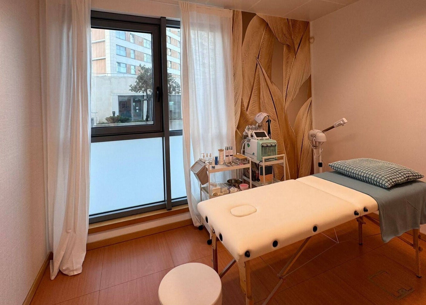 Sala de tratamento relaxante no Bella Face em Lisboa, Lisboa, PT, com maca e janela iluminada.