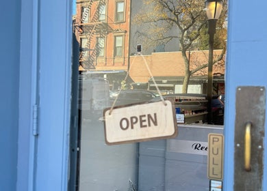 Entrance to New L&T Nail Spa INC in New York, New York, US with open sign on blue door.