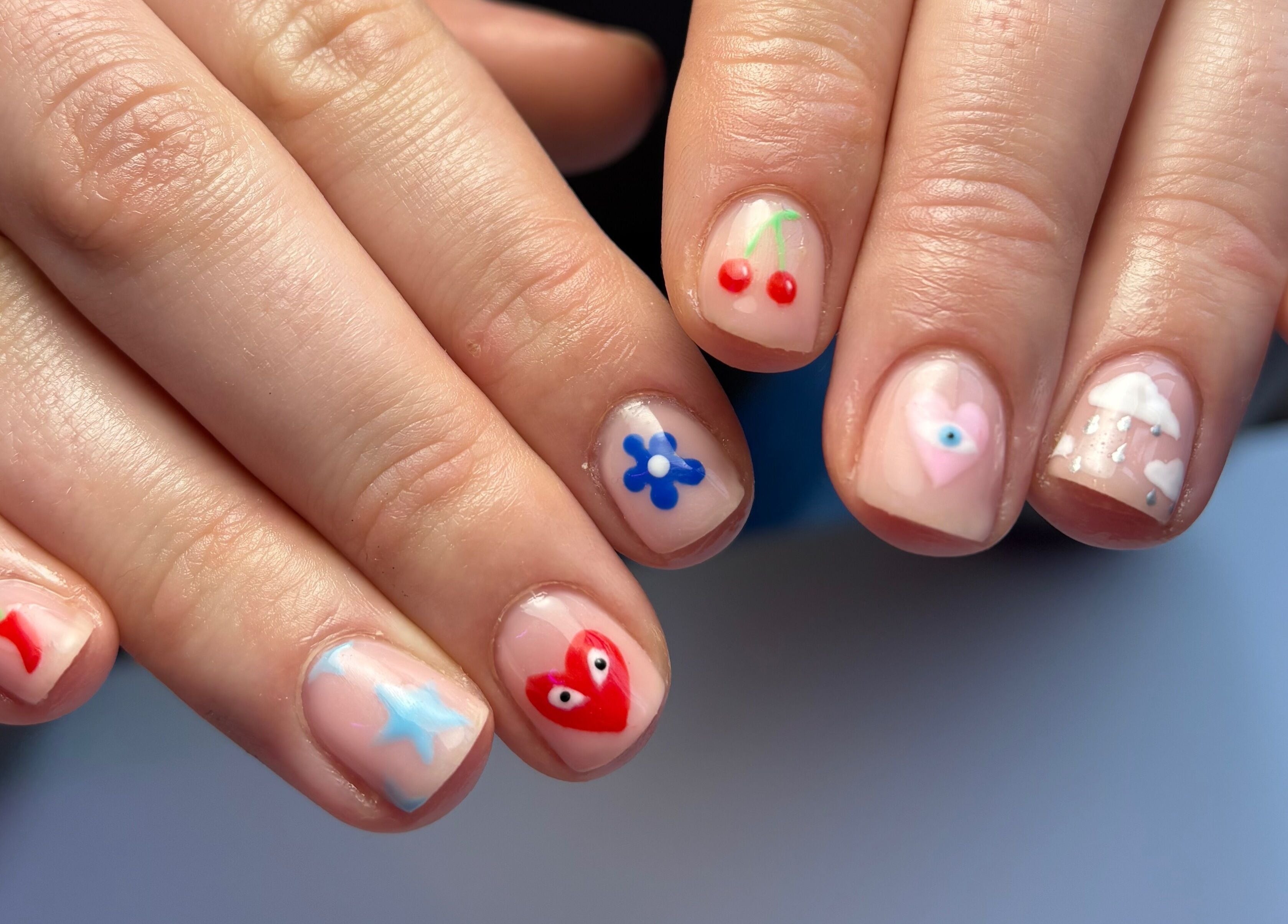 Vibrant nail art at Glos Nails by April, Shirley, England, GB, showcasing cherry and floral designs.