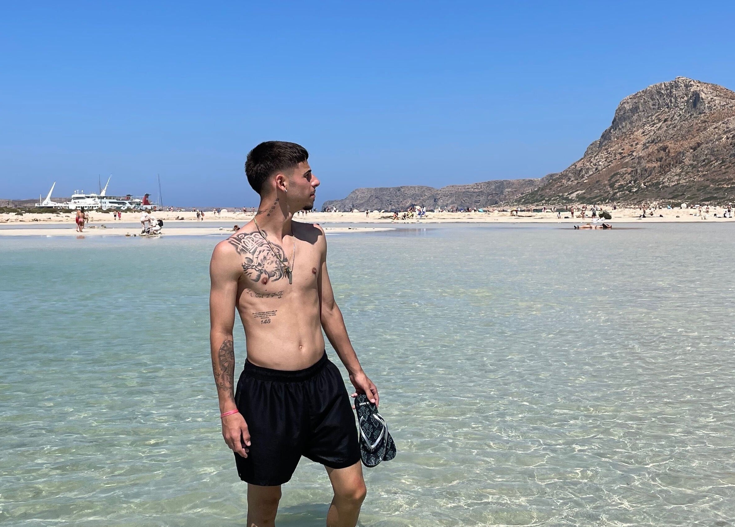 Young man stands by clear water at serene beach, perfect relaxation spot, IzzyCuts, Klierf, Kanton Klierf, LU.