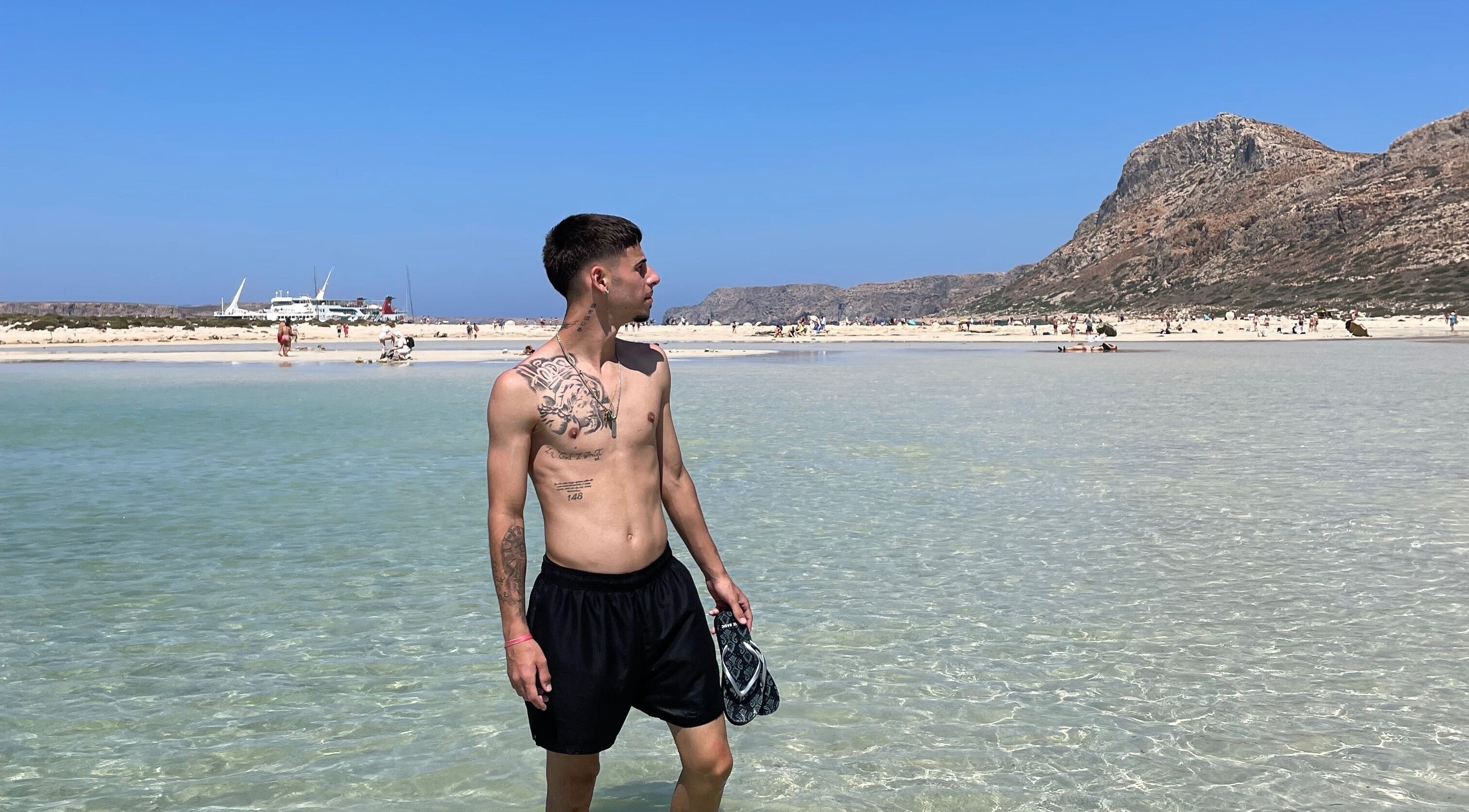 Young man stands by clear water at serene beach, perfect relaxation spot, IzzyCuts, Klierf, Kanton Klierf, LU.
