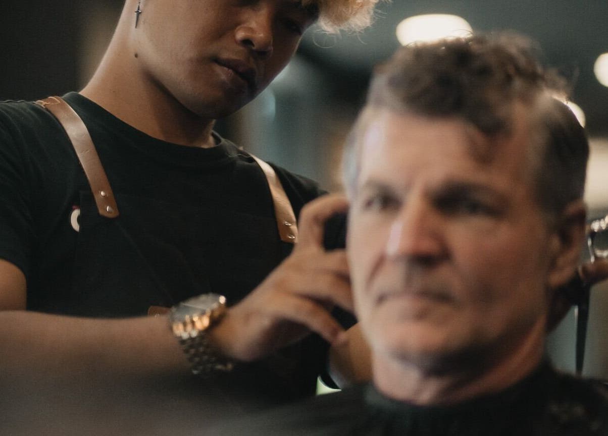 Barber at Stevie's in Bali, Bali, ID gives a precise haircut to a customer in a stylish setting.