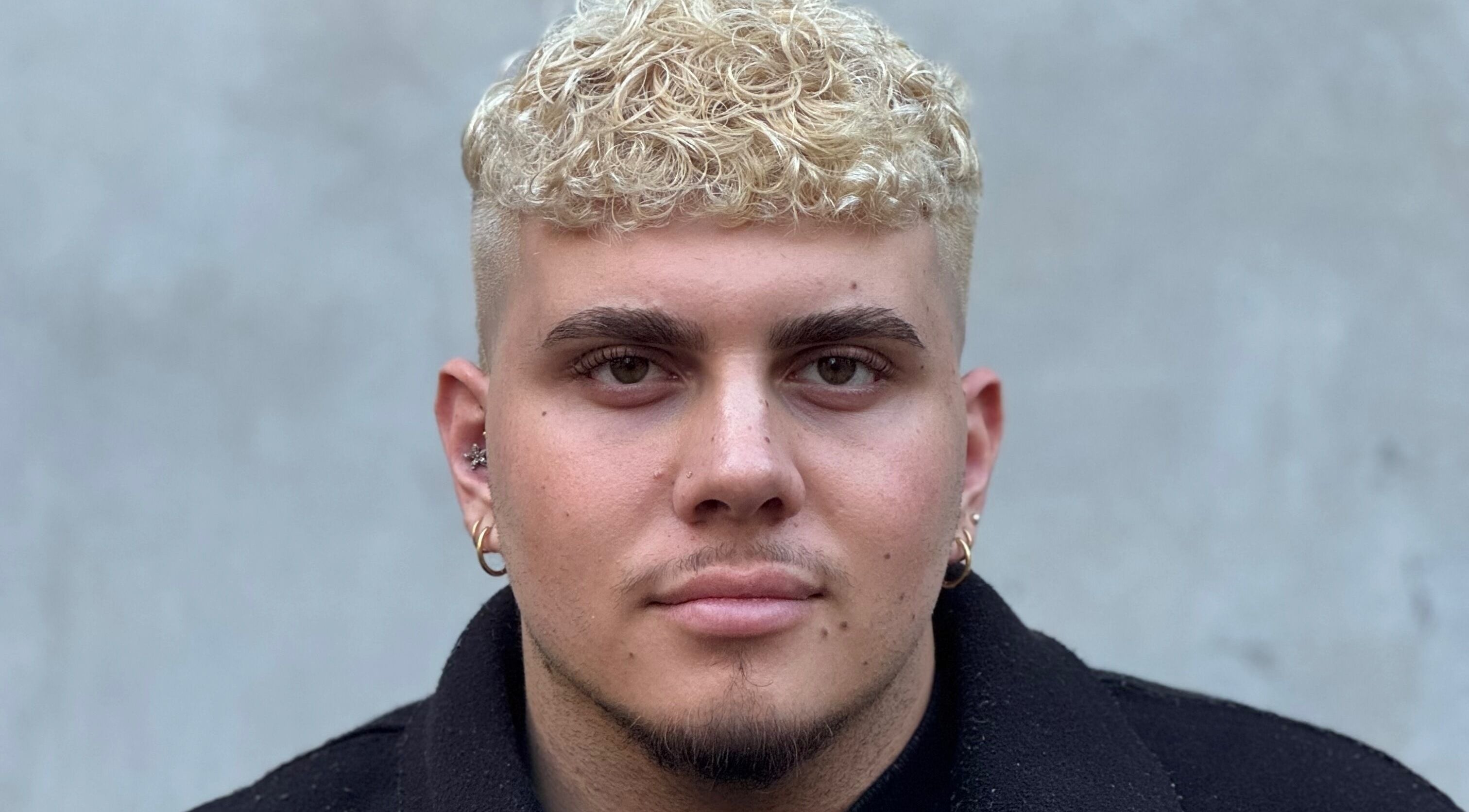 Trendy curly blonde hairstyle for men at Sarah Hall Hair, Surry Hills, New South Wales, AU.