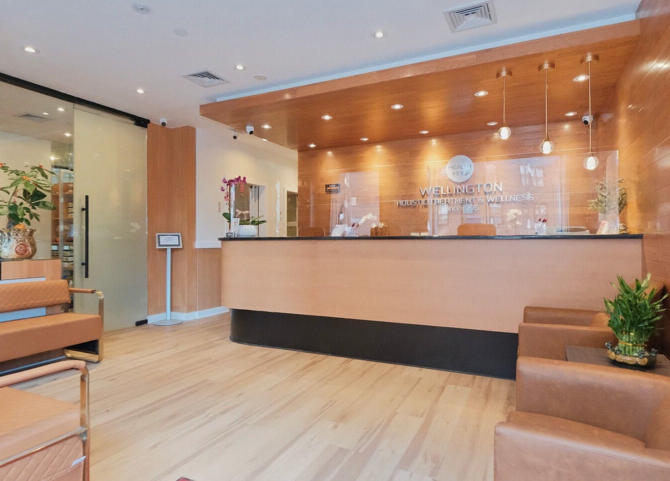Reception area at Healthkey Group Wellington - Elmhurst in New York, New York, US, featuring warm wood tones.