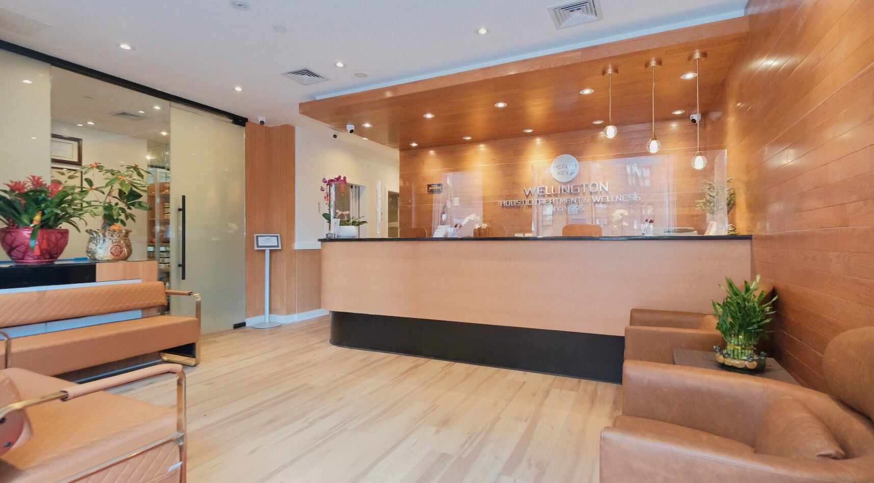 Reception area at Healthkey Group Wellington - Elmhurst in New York, New York, US, featuring warm wood tones.