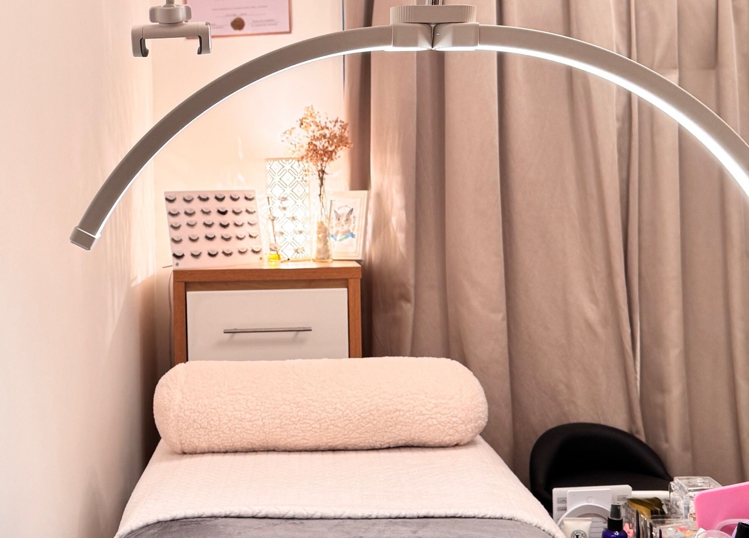 Elegant treatment room at Curl Lashes in Bristol, England, GB with ambient lighting and comfortable bedding.