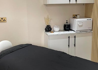 Calming treatment room at The Coven Hair Lounge, Aylesbury, England, GB with a massage bed and soothing decor.