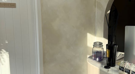 Cozy corner at The Coven Beauty Lounge, Aylesbury, England with a candle and diffuser on a marble surface.