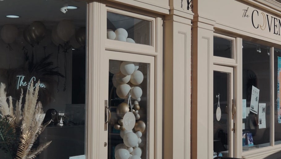 The Coven Hair Lounge facade with elegant balloons in Aylesbury, England, GB.