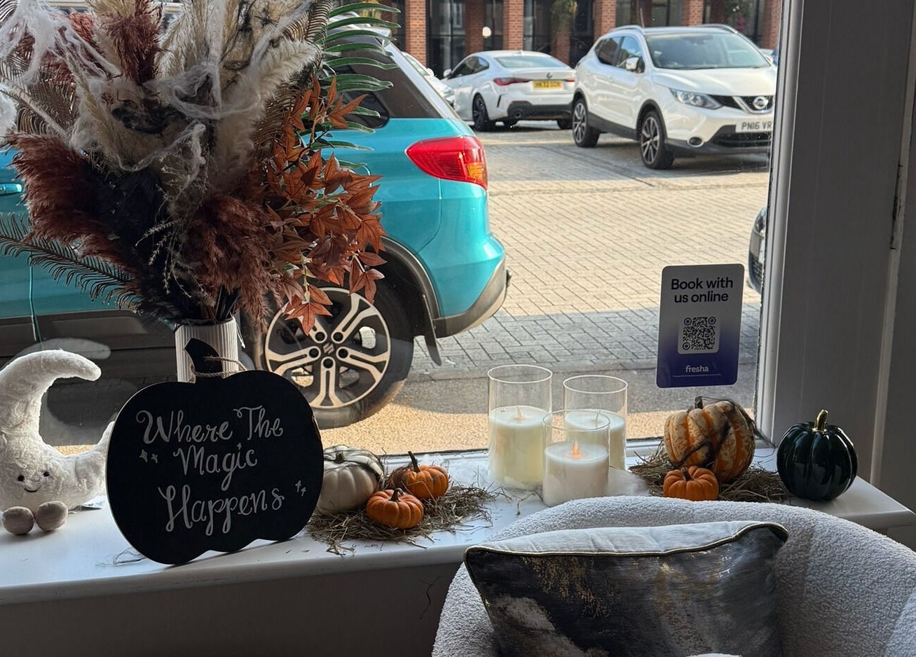 Cozy window display at The Coven Hair Lounge, Aylesbury, England, GB with decor and autumn accents.