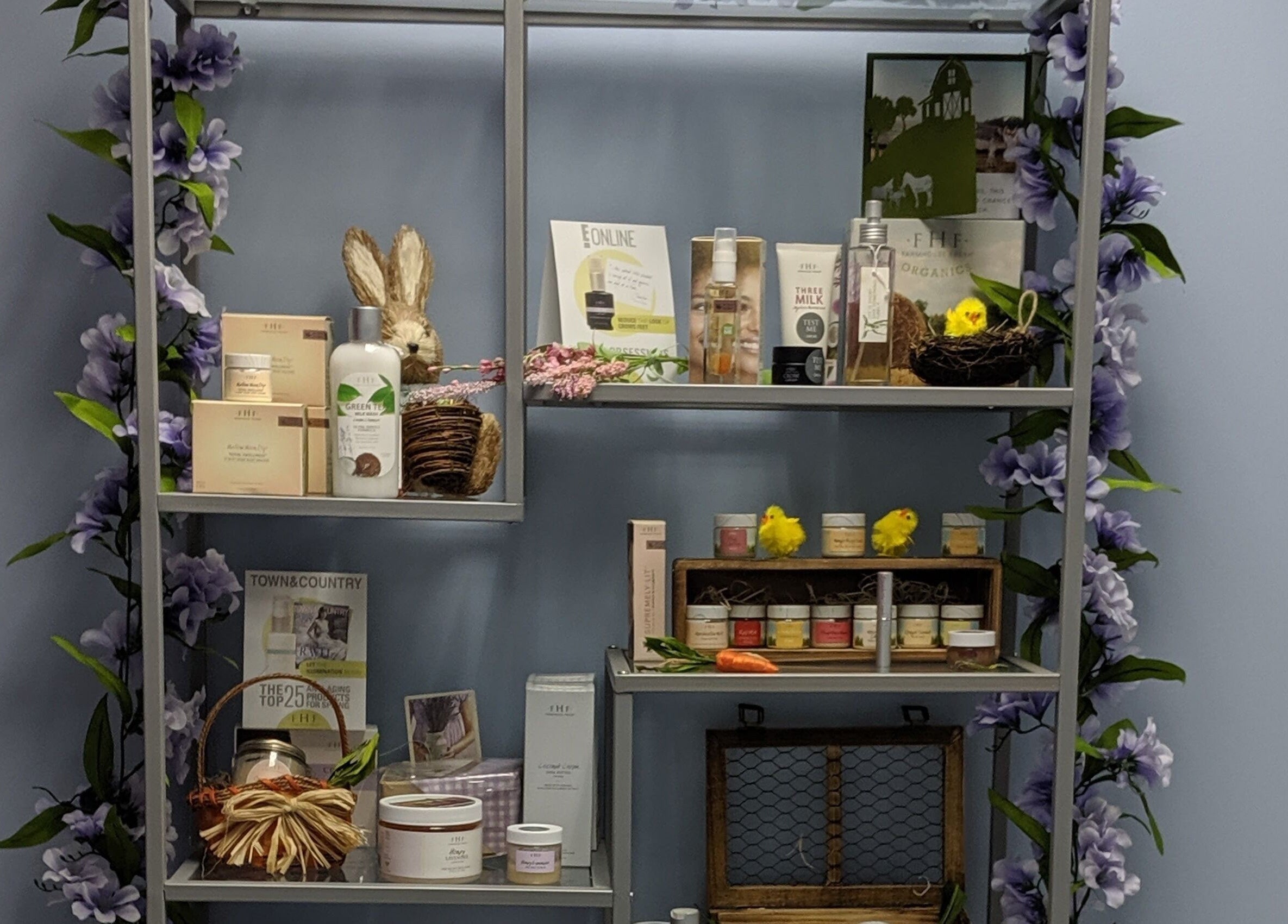 Beauty products on decorative shelf at Face Reflections, Inc., Bloomingdale, Illinois, US, adorned with purple flowers.