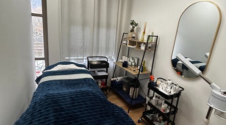 Relaxing treatment room at Skin Reboot, Cape Town, Western Cape, ZA with cozy bed and well-organized shelves.
