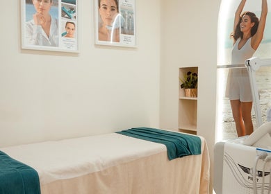 Calm spa room at Fresh N Fab Hair Beauty Ladies Salon in Dubai, Dubai, AE with a massage bed and posters.