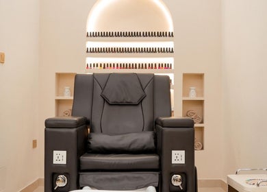 Luxurious pedicure chair at Fresh N Fab Hair Beauty Ladies Salon in Dubai, Dubai, AE, among nail polish displays.