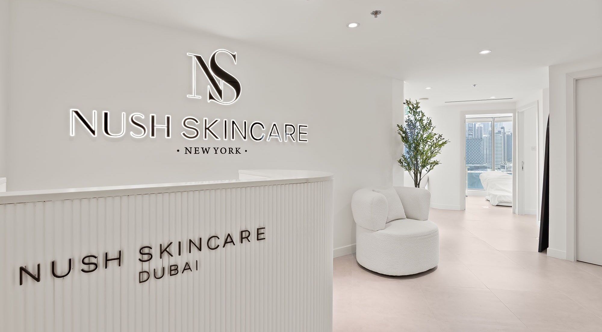 Reception area of Nush Skincare Dubai, Dubai, AE, featuring sleek modern decor and a cozy lounge chair.