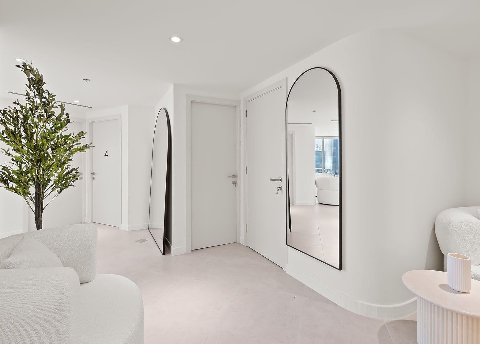 Modern, minimalist waiting area at Nush Skincare Dubai, featuring sleek mirrors and plush seating, Dubai, Dubai, AE.